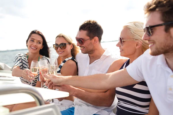 Smiling friends with glasses of champagne on yacht