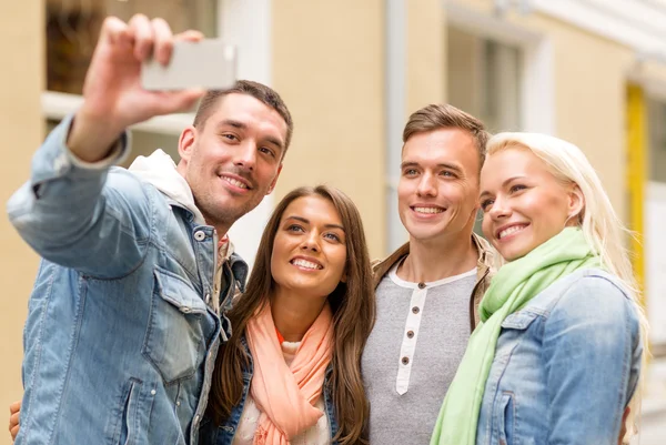 Group of smiling friends making selfie outdoors
