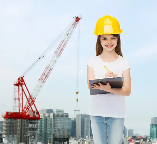 Smiling little girl in hardhat with clipboard