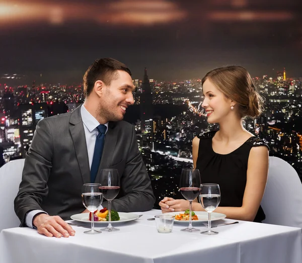 Smiling couple eating main course at restaurant