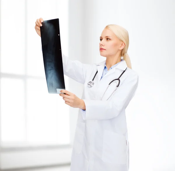 Serious female doctor looking at x-ray