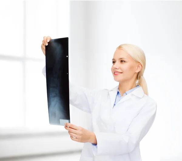 Smiling female doctor looking at x-ray