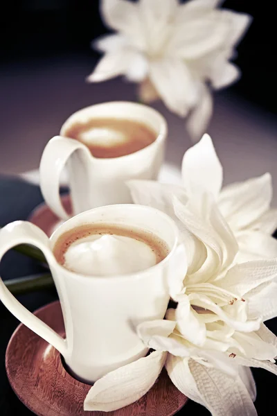 Cups of milk coffee with flowers