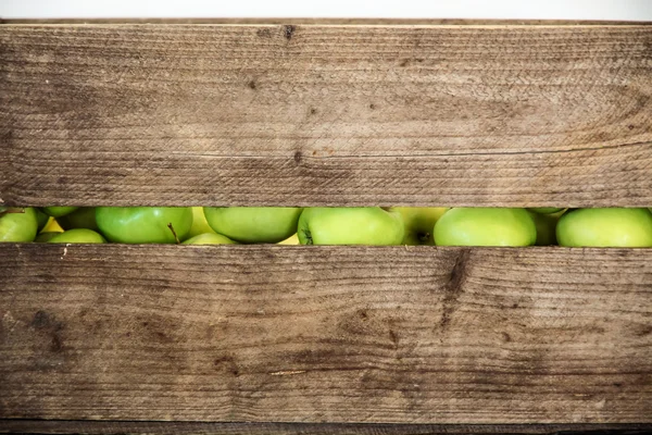 Green apple in a wooden box