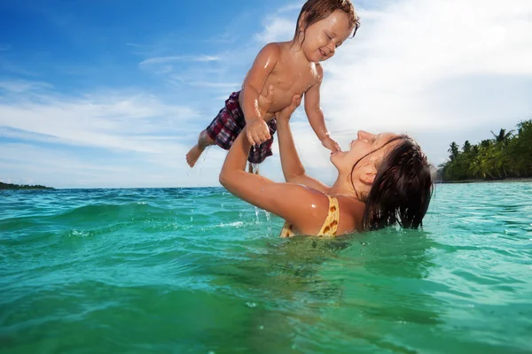 Mother play with her son in the sea