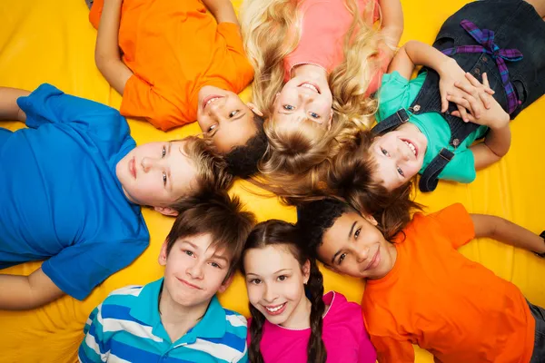 Group of happy kids laying in circle
