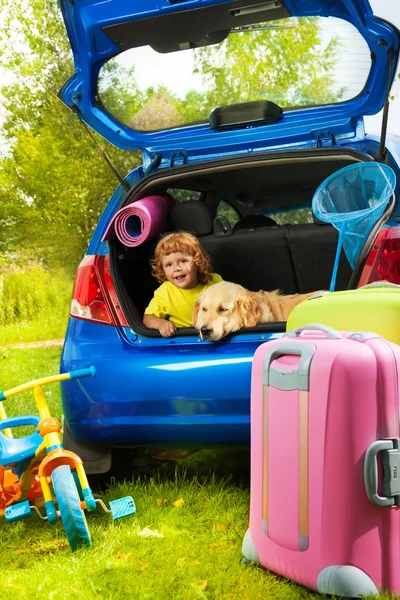 Boy and dog in the trunk waiting