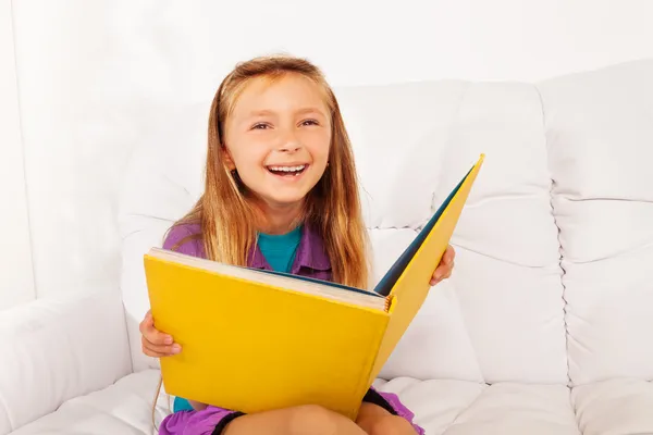 Laughing smart girl with book