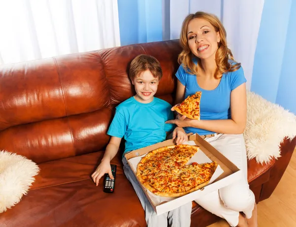 Boy and his smiling mother eating pizza