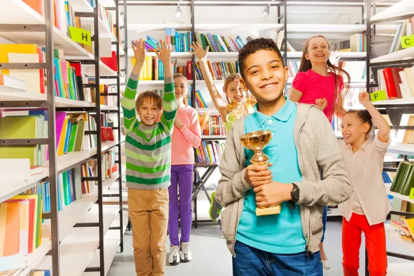 Boy holds cup  in library