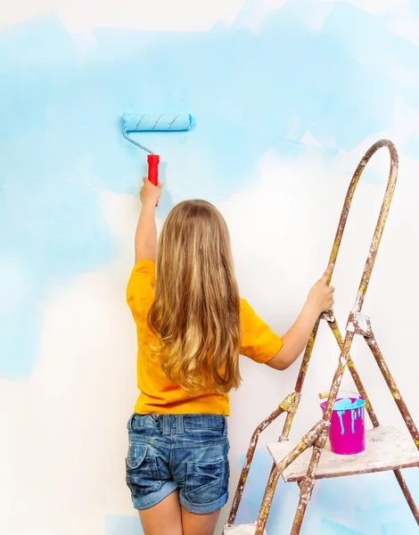 Girl paints the wall