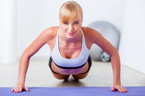 Blonde woman doing push-ups
