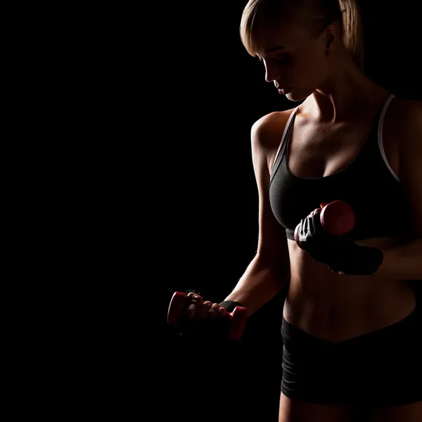 Woman holding red dumbbells