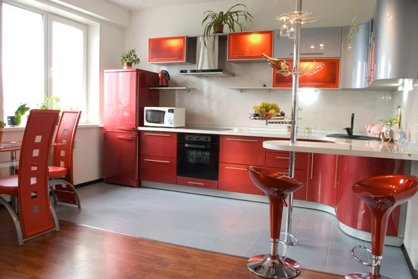 Interior of modern kitchen with a bar counter in red tones