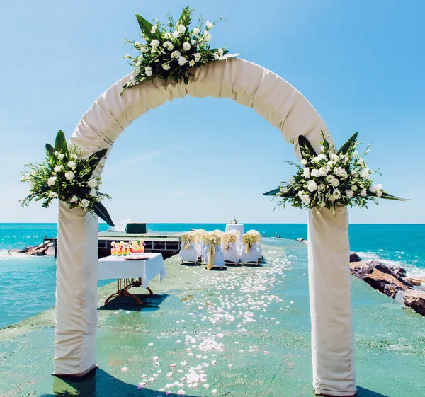 Wedding arch and wedding chairs on the empty beach