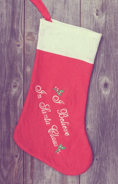 Vintage image of Christmas stocking on wooden background