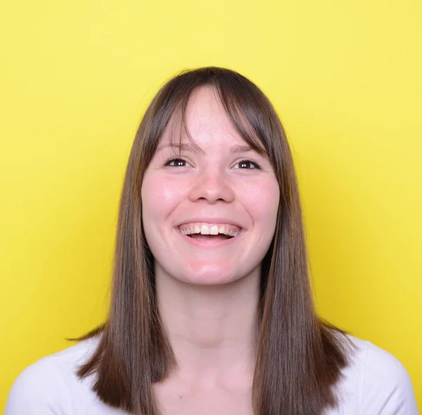 Portrait of beautiful young woman smiling against yellow backgro