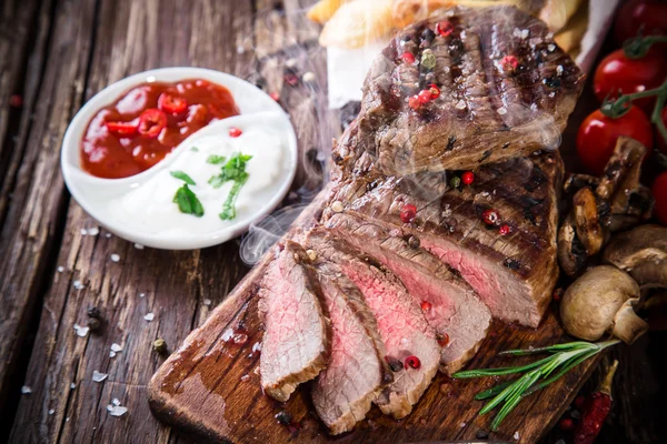 Tasty beef steak on wooden table