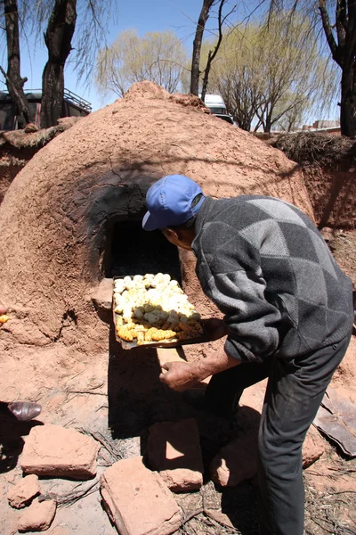 Indian old man cooking in Native Clay Oven