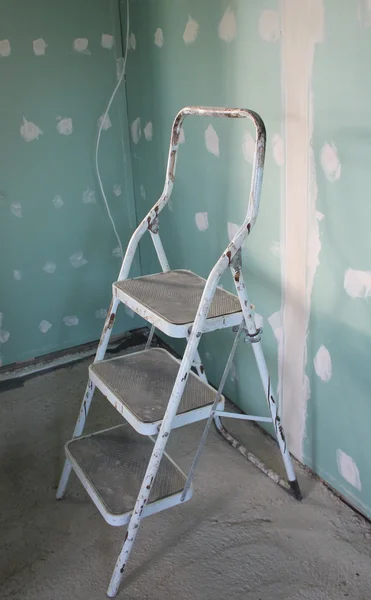 Step stool and wall daubed with plaster