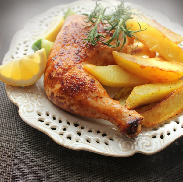 Roasted chicken leg with fried potato and lemon
