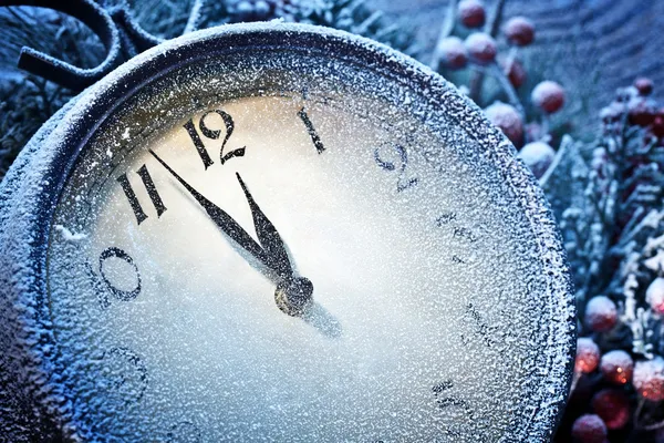 New Year clock powdered with snow.