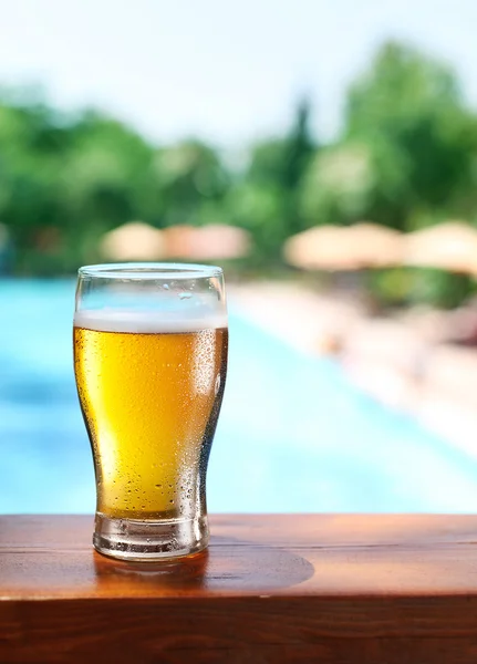 Cold beer glass on the bar table at the open-air cafe.