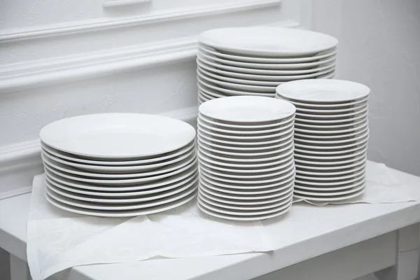 Set of clean plates at the white table.