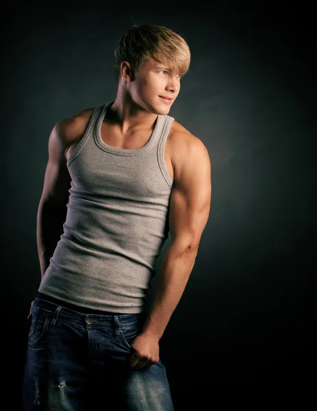 Beautiful young strong man posing on studio