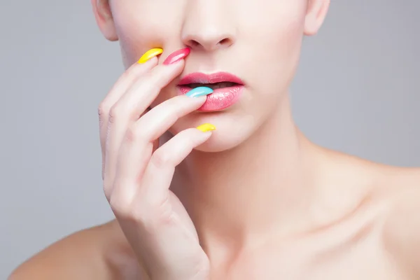 Colored manicure, Woman face with rainbow makeup and manicure