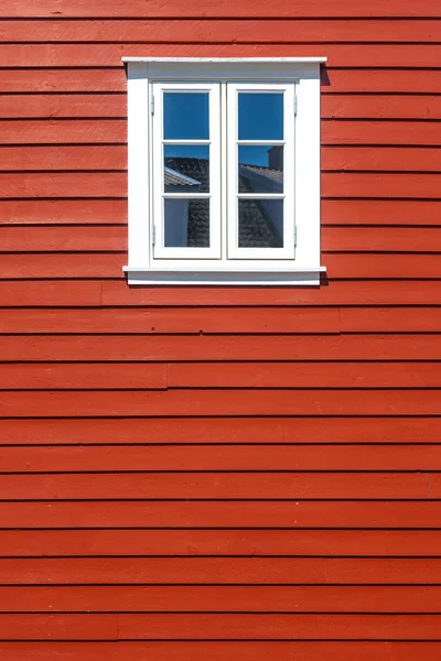 White wooden window on the red wooden house wall