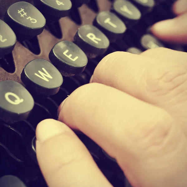 Typing on an old typewriter, with a retro effect