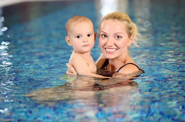 Young cheerful mother and little son in a swimming pool