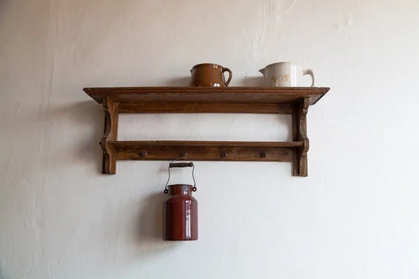 Old wooden shelf with milk jug