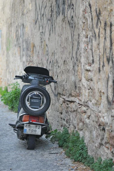 Honda motorcycle at the foot of the wall.