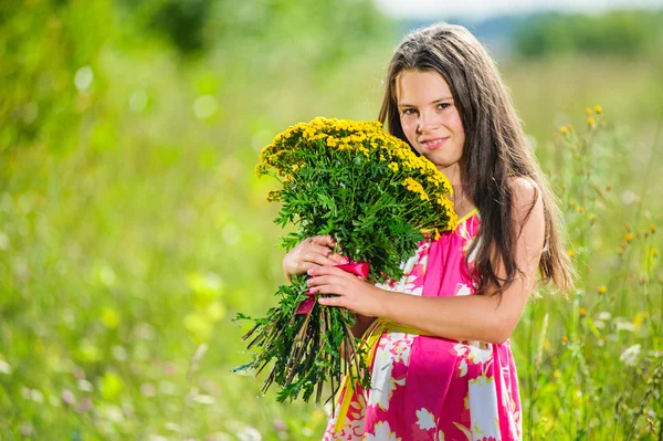 Portrait of school girl among the flowers in summer time