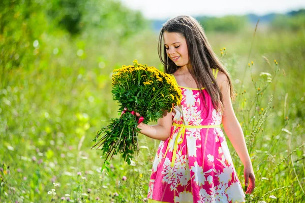 Portrait of school girl among the flowers in summer time