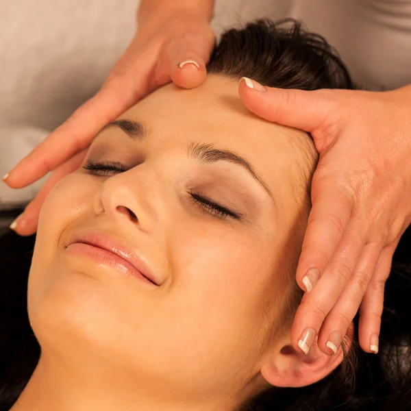 Woman having face massage treatment in wellness