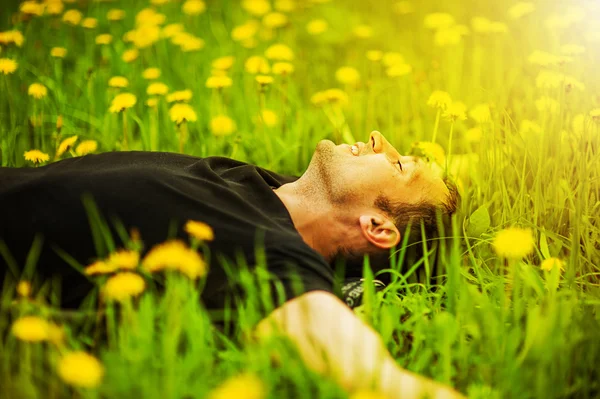 Man lying on grass at sunny day