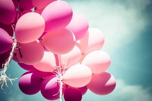 Pink balloons and blue sky background