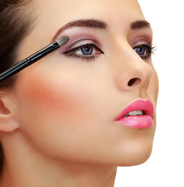 Eyes makeup. Brush applying eye shadows on beauty woman face. Cl