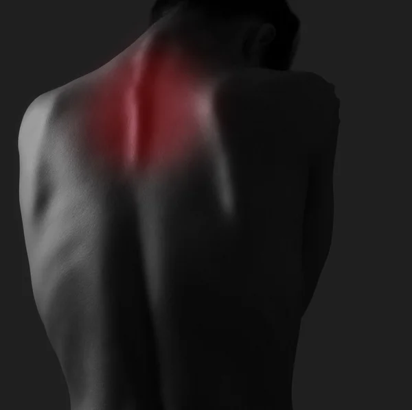 Pain in woman neck on dark background. Injury