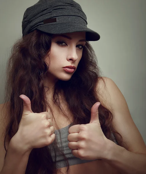 Happy joy teen girl in fashion cap with thumb up sign. Closeup vintage portrait