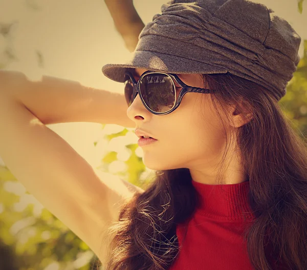 Sexy fashion model in sun glasses and cap. Closeup vintage portrait