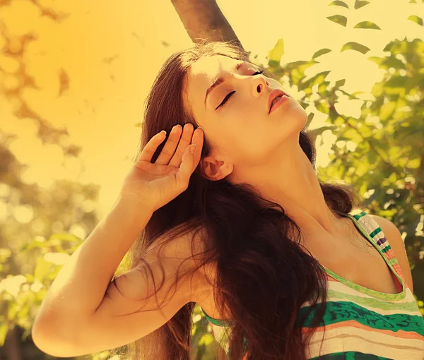 Freedom and happiness. Beautiful woman joy on bright sun light background with closed eyes