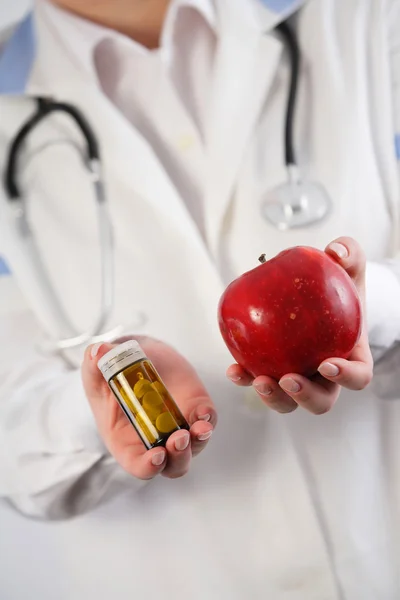 Apple vs. drugs in doctor's hands.