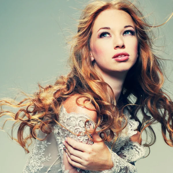 A portrait of stylish elegant redheaded girl is in lace clothes .