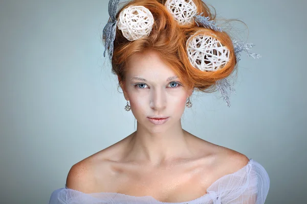 Redheaded girl with new-year decorations in a hair-do. Beautiful New Year and Christmas Tree Holiday Hairstyle and Make up.