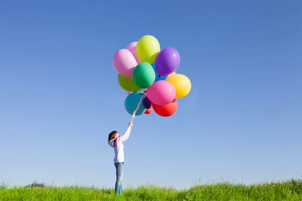 Happy woman jumping with balloons
