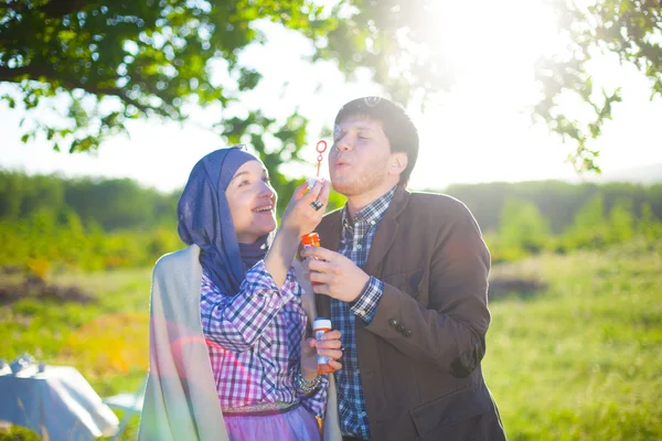 Young couple play together with bubble blower